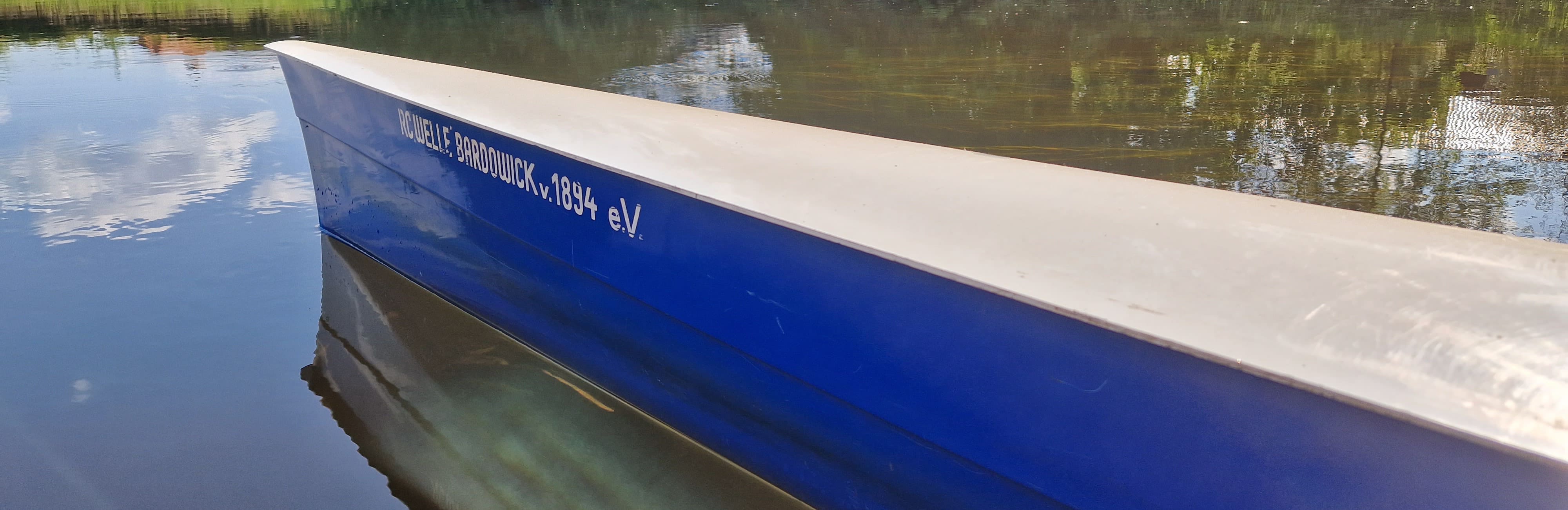 Ein blaues Boot liegt sanft auf dem Wasser, umgeben von einer friedlichen und ruhigen Landschaft.