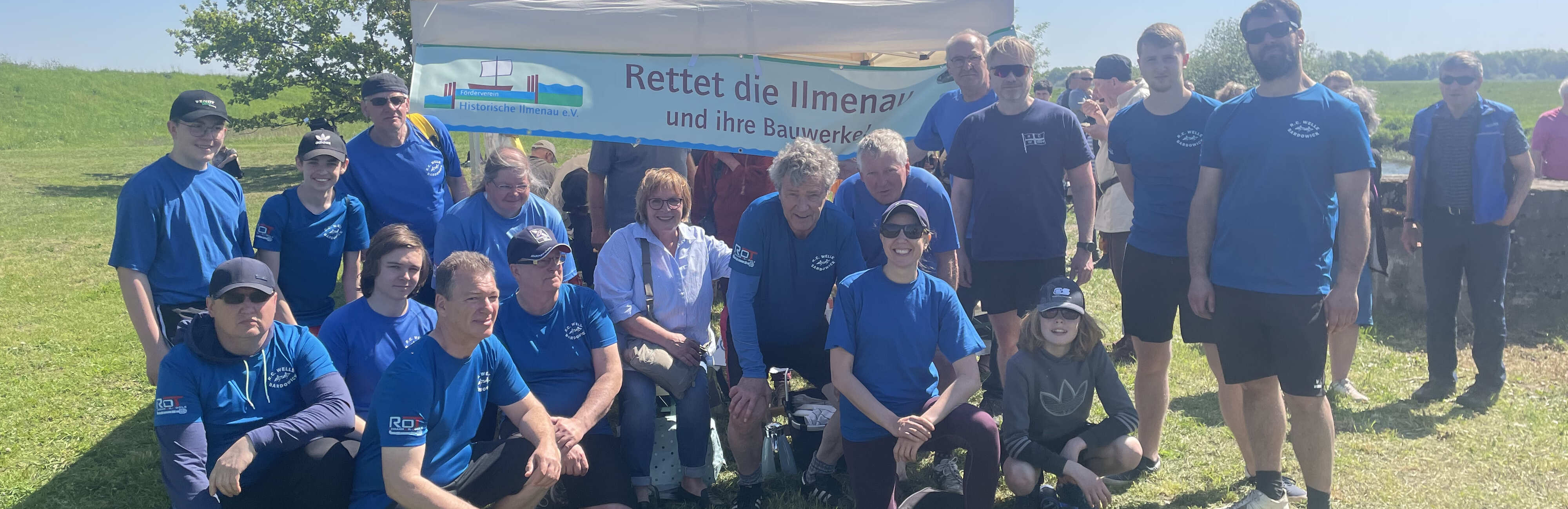 Vereinsmitglieder vor einem Banner mit der Aufschrift Rettet die Ilmenau.